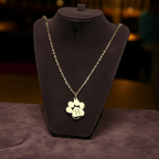 Necklace with paw-shaped pendant on a dark stand against a blurred background